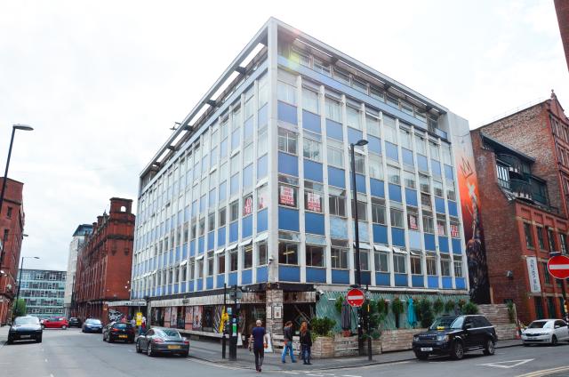 A photo of an office block in Manchester with blue and white 1960s windows