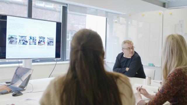 a design review in the Buttress studio - a group of people are reviewing designs on a large TV screen