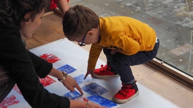 A child taking part in a Buttress creative workshop, creating paint prints