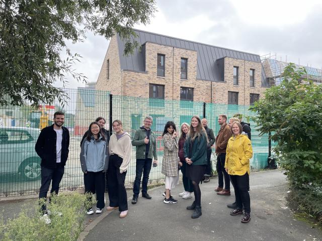 Colleagues gathered on a wellbeing walk outside a residential block