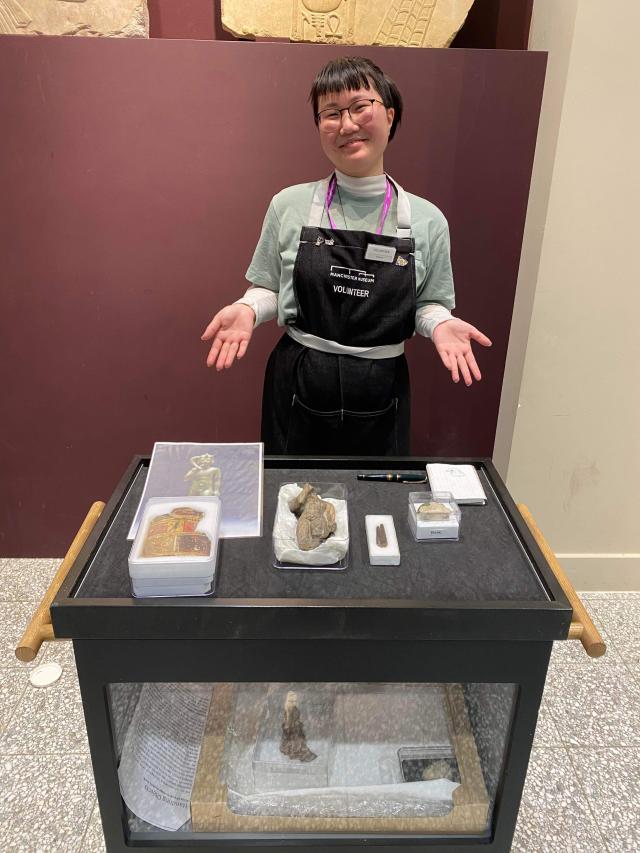 Deborah standing with historical artifacts in a museum.