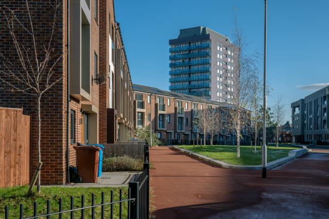 Street in Brunswick - brick houses and a grey tower in the background.