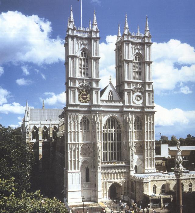 West front of Westminster Abbey - a white cathedral facade with two towers set against a blue sky.