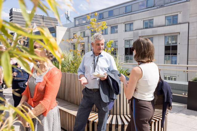 A group of people talking on a rooftop terrace