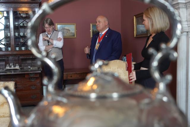 Photo of three people stood in a Georgian style room.
