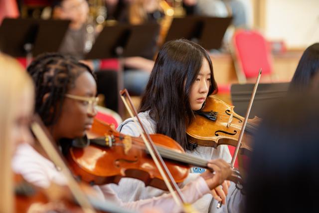 Two students playing the violin.